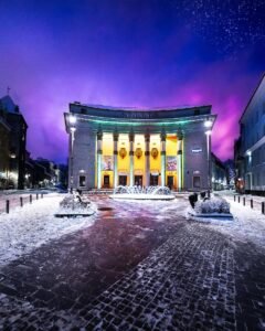 Night photograph of the Sõprus Cinema in Tallinn’s Old Town, with snowy foreground, purplish-blue sky dotted with stars, and softened city lights — taken by George Adamides, author